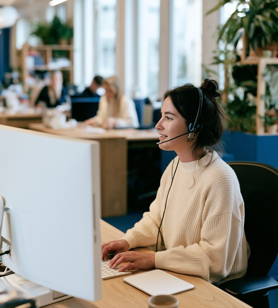 Claims handler on a call, typing at her computer